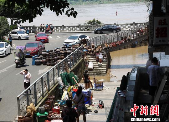 图为洪峰过境重庆主城，低洼路段出现积水，沿江商户正在紧急转移货物。　周毅　摄