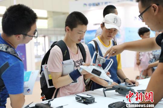 市民向工作人员咨询无人机。 胡耀荣 摄 市民向工作人员咨询无人机。 胡耀荣 摄