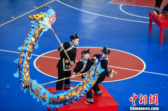 华侨大学的大学生身着畲族服饰在狭小的方桌上舞起了三人龙。 杨华峰 摄 华侨大学的大学生身着畲族服饰在狭小的方桌上舞起了三人龙。 杨华峰 摄