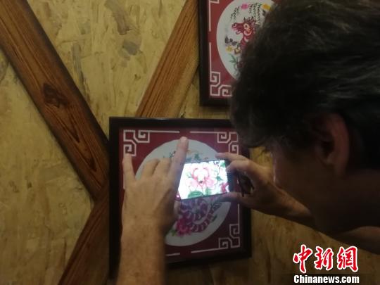 7月13日,在位于江西上饶市横峰县的中国剪纸文化展示馆,奥利维???戈舒??对于中国的剪纸艺术产生极大的兴趣。图为奥利维???戈舒??用手机拍摄剪纸作品。 苏路程 摄 7月13日,在位于江西上饶市横峰县的中国剪纸文化展示馆,奥利维???戈舒??对于中国的剪纸艺术产生极大的兴趣。图为奥利维???戈舒??用手机拍摄剪纸作品。 苏路程 摄