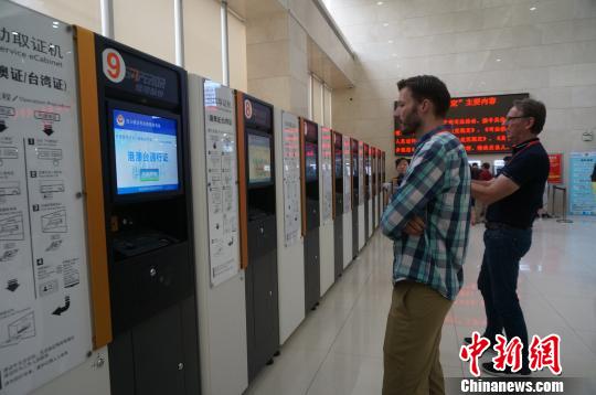 驻华执法联络官们对中国自助办理护照、出入境证件的方式十分感兴趣。 韩章云 摄 驻华执法联络官们对中国自助办理护照、出入境证件的方式十分感兴趣。 韩章云 摄