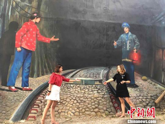 7月13日，在江西省上饶县“网红村”周石村，游客模仿3D立体墙中的情景。　颜子玉供图　摄