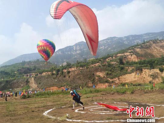 14日当天，30名滑翔伞运动员依次从崛围山山顶跳落，场面蔚为壮观，赢得现场观众一阵阵尖叫声。　刘小红 摄