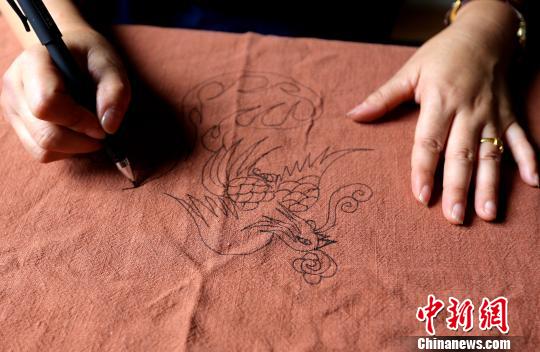 一名苗族绣娘在练习传统苗绣基础画法。　石峰 摄