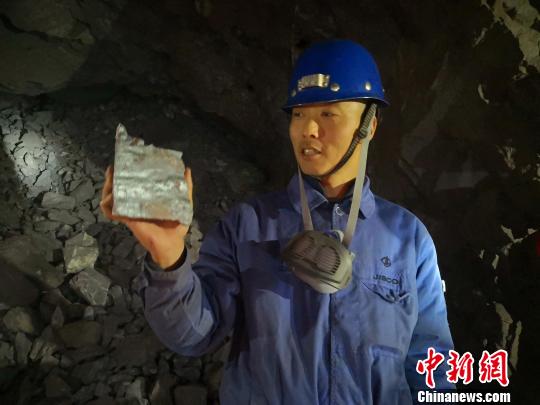 图为镜铁山矿桦树沟矿区工作人员介绍开采出来的铁矿石。　魏建军 摄