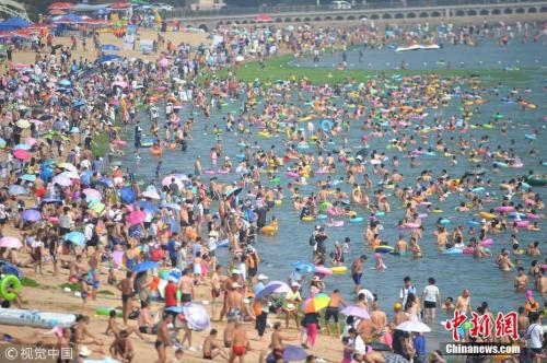 7月29日，数千名游客在山东青岛第一海水浴场纳凉避暑。 王海滨 摄 图片来源：视觉中国