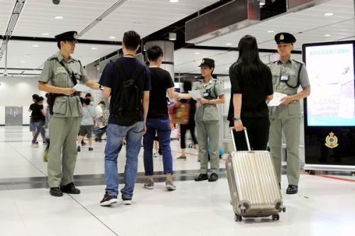 香港海关人员暑假期间在边境管制站派发传单。图片来源：香港政府新闻网