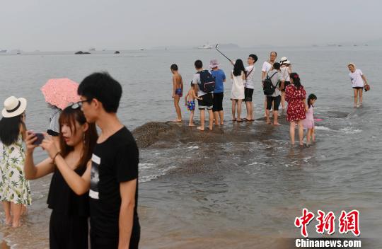 游客在厦大海滩拍照留念。　吕明 摄