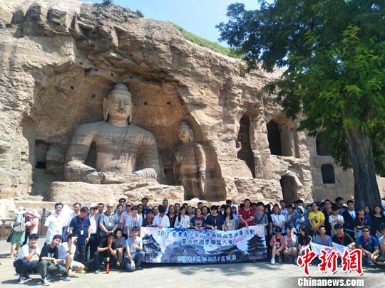 图为:港澳青少年在大同云冈石窟景区合影留念。 刘小红 摄 图为:港澳青少年在大同云冈石窟景区合影留念。 刘小红 摄