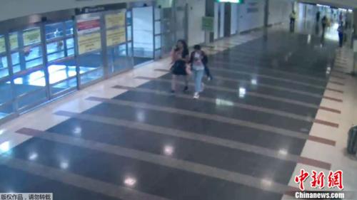 华盛顿都会区机场管理局公布的照片显示12岁的马金晶(译音)2018年8月2日与一名女子走过里根国家机场的“行李/抵达”楼层。