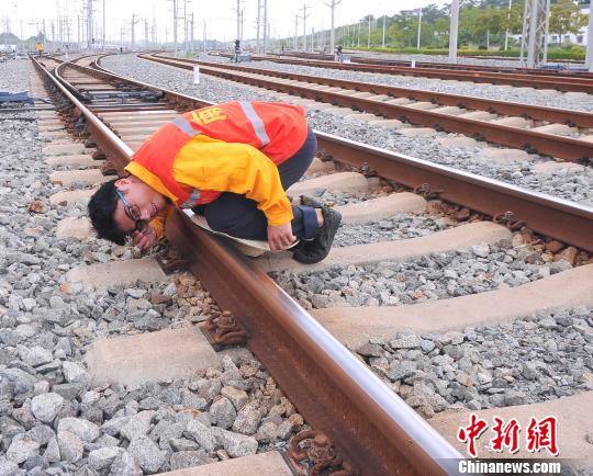 检修工人趴在50多度高温的铁轨上，目测线路的平整度。　蒋雪林　摄