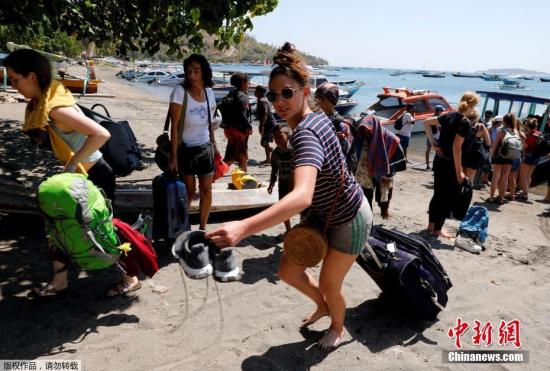 图为游客从龙目岛撤离。