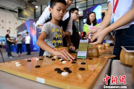 图为一名儿童使用智能棋盘与人工智能系统对弈。　俞靖 摄