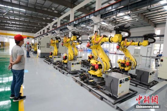 8月3日，长沙，众多机器人在厂房内集体跳舞。这些机器人由长泰机器人研制，兼具高速度与高精度双重优点及灵活的机械手腕，是一款低成本高性能的六轴轻型机器人，重复定位精度可达0.05毫米。中新社记者 杨华峰 摄