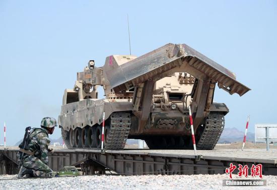 8月8日，“国际军事比赛-2018”“安全路线”工兵分队接力赛在新疆库尔勒举行，中国队最终以优异成绩夺冠。图为中方参赛车辆通过架设好的桥梁。 袁凯 摄