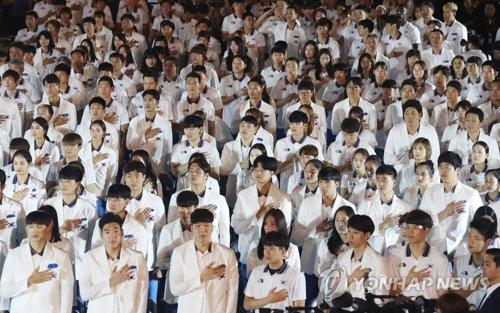 8月7日，在首尔奥林匹克手球竞技场举行的亚运会代表团成立仪式上，选手们向国旗致敬。（韩联社）