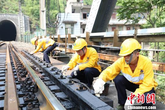 图为工作人员正在为位于位于重庆市北碚区的嘉陵江铁路钢大梁桥木枕涂沥青。 晏涛 摄 图为工作人员正在为位于位于重庆市北碚区的嘉陵江铁路钢大梁桥木枕涂沥青。 晏涛 摄