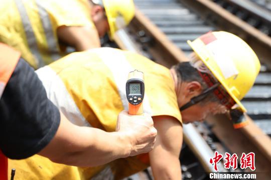 14日上午11时许,钢轨温度已接近60℃。图为温度计显示当时温度为60.9℃。 晏涛 摄 14日上午11时许,钢轨温度已接近60℃。图为温度计显示当时温度为60.9℃。 晏涛 摄