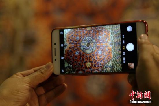 市民用手机拍摄展出的中国古毯。孙睿 摄