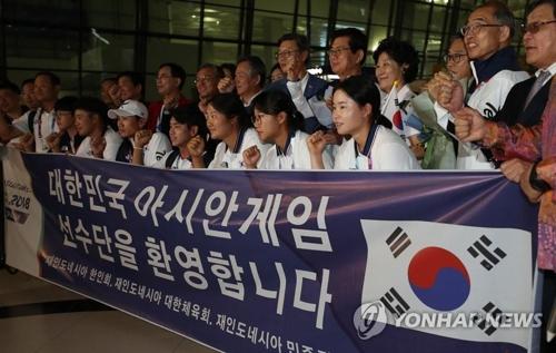 8月15日，在苏加诺?哈达机场，韩国代表队下机后合影。（图片来源：韩联社）