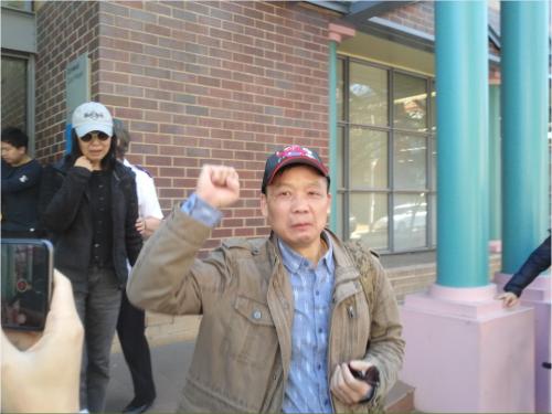 俞琪父亲神情悲伤高举拳头，与俞琪母亲一同离开法院。(图片来源：澳大利亚新快网)
