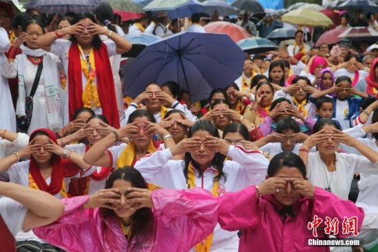 6月21日，国际瑜伽日，尼泊尔首都加德满都细雨蒙蒙，但挡不住民众练瑜伽的热情。图为尼泊尔民众在练习瑜伽。 中新社记者 张晨翼 摄