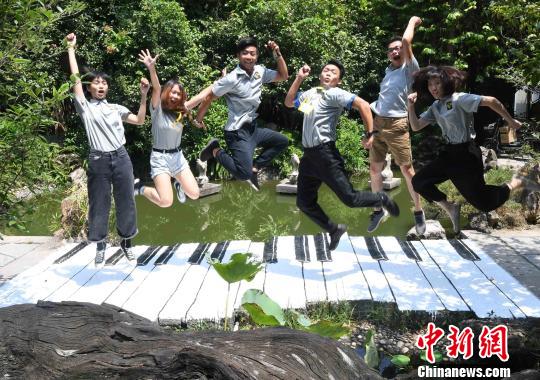 首次来大陆的台湾青年在福州市温泉公园艺博园内创作完成的彩绘作品《钢琴步道》上，留下象征音符跳跃瞬间影像。　记者刘可耕 摄