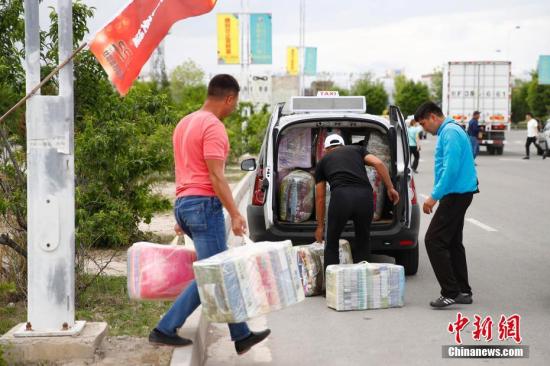 资料图：在中哈霍尔果斯国际边境合作中心，哈萨克斯坦顾客把货物塞满汽车。中新社记者 富田 摄