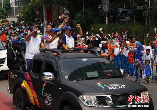 资料图：8月16日，第十八届亚运会火炬接力活动在印尼首都雅加达举行，当地民众热情迎接火炬的到来。中新社记者 侯宇 摄