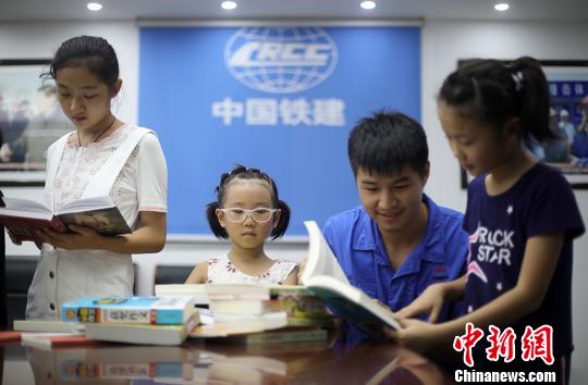 中铁十四局南京五桥项目的工作人员也为孩子们准备了书籍等学习用品。　泱波　摄