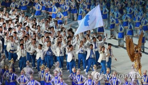 身着白衣蓝裤、手举半岛旗 亚运会开幕式朝韩再携手赢掌声
