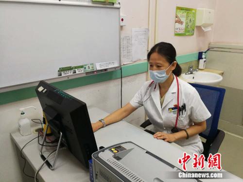 杨爱君在诊室工作 中新网记者 张尼 摄