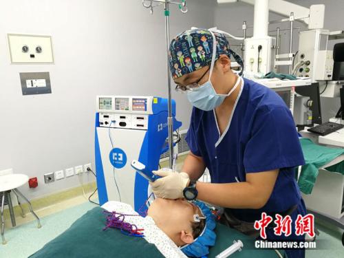 孙浩睿在手术开始前为麻醉后的病人进行气管插管。 中新网记者 张尼 摄