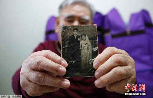 韩国老人Jang Choon在家中展示他在朝鲜的弟弟的照片。
