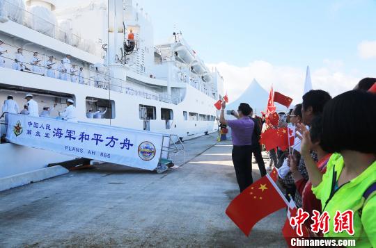 8月20日，在汤加努库阿洛法港码头，华侨华人挥动中汤两国国旗为中国海军和平方舟医院船送行。　史奎吉 摄