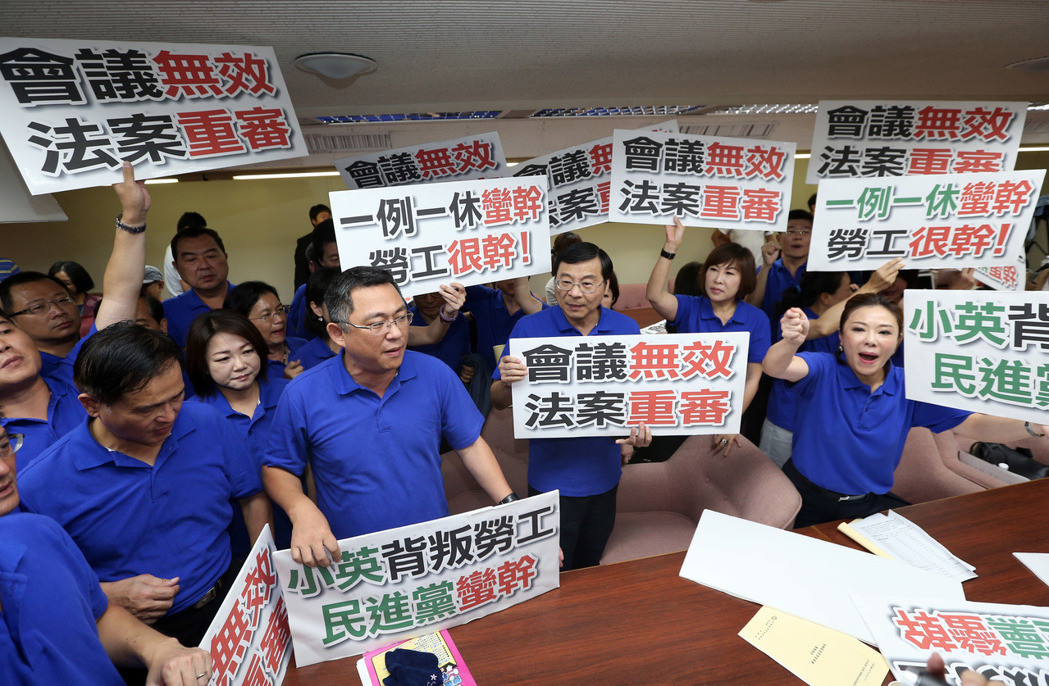 　　图为国民党“立委”高举抗议标语，要求“一例一休”会议无效、“法案”重审。（图片取自台湾《联合报》）