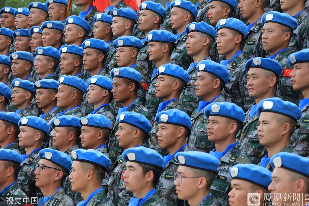 维和官兵头戴蓝色贝雷帽,身穿佩带中国国旗和un臂章的迷彩服,踌躇满志