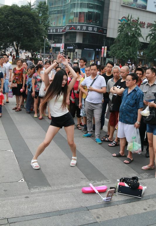 7月13日,重慶觀音橋商圈,一位網絡女主播進行戶外直播,現場熱舞,吸引