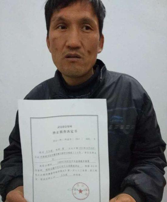 图为王玉虎拿着灵宝警方的终止侦查决定书.