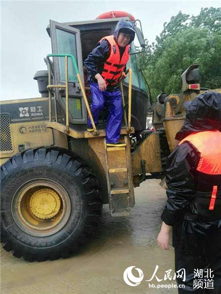 堤坝溃口20余人被围困厂房 民警铲车施救筑起人墙通道