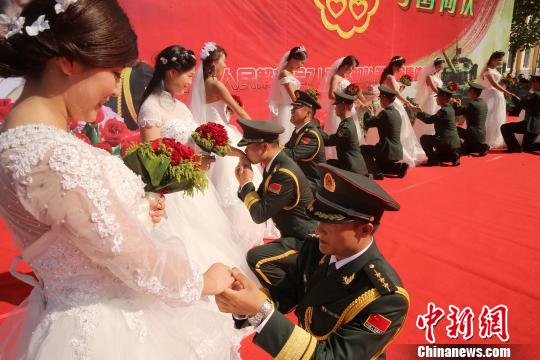 新郎为新娘戴上特殊的弹壳戒指. 于华良 摄