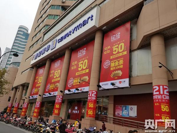 杭城超市外面挂出双12巨幅活动广告(央广网记者 张国亮 摄)
