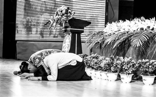 &uarr;该校举办的论坛上登台"忏悔"的母女给台下观众跪下磕头