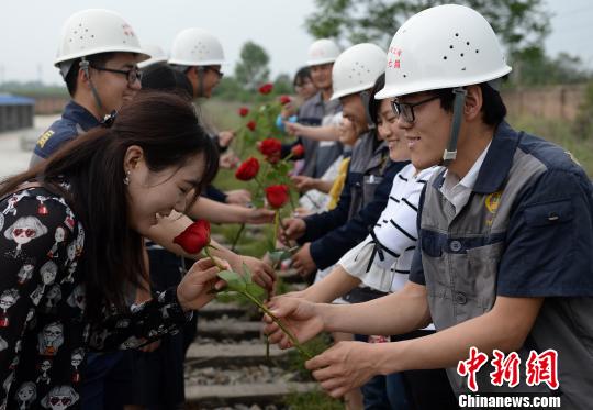 图为男青年们在一条废弃的铁路线上为女青年送上玫瑰. 刘潇 摄