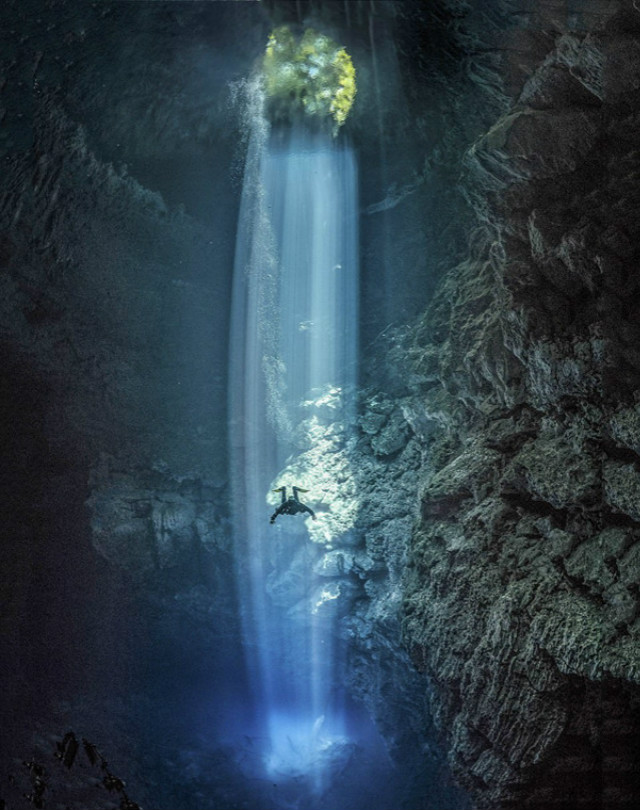 阳光穿越墨西哥水下洞穴潜水员光束内下潜水