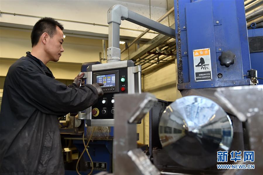 山西长治市潞安集团太阳能科技有限责任公司的工人在操作单晶硅棒