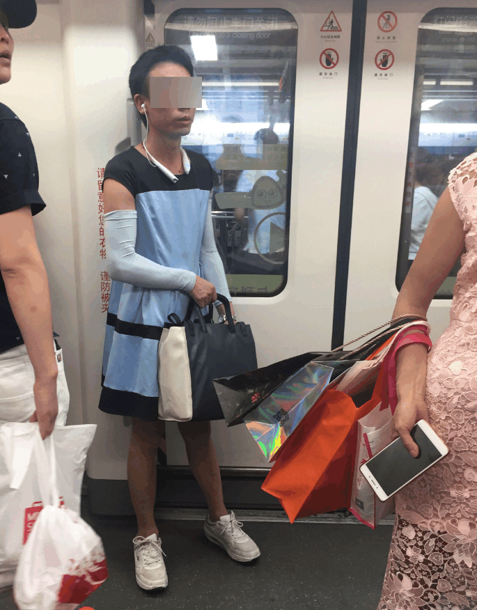 广州一男子身穿蓝裙拎女士包搭地铁