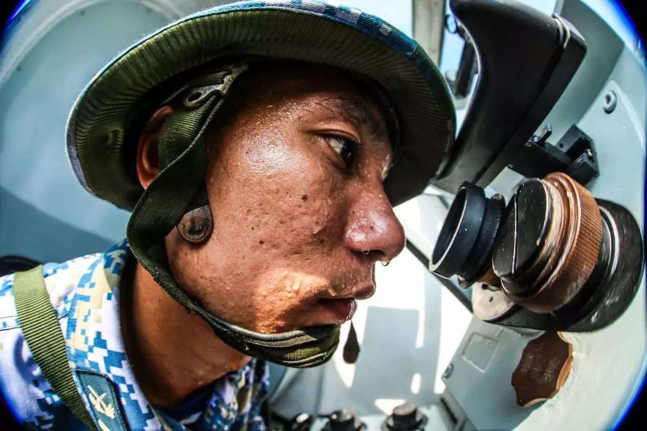 兵林华斌一手拿着板刷,一手手持装备,在上铜油,豆大的汗珠挂满脸庞