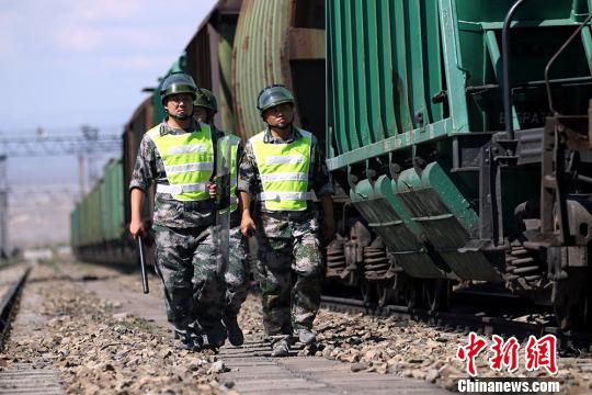 圖為第五師九十團駐阿拉山口鐵路護路民兵在檢查火車周邊情況.