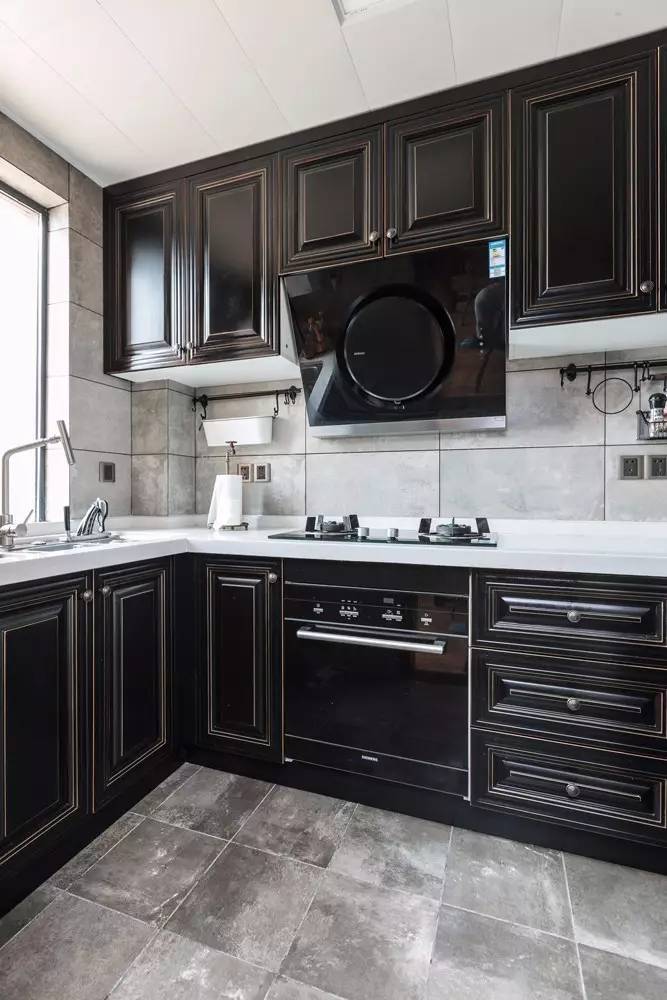 ▼黑色橱柜面板,搭配黑色烟机风口与黑色的消毒柜,整个厨房都呈现出一